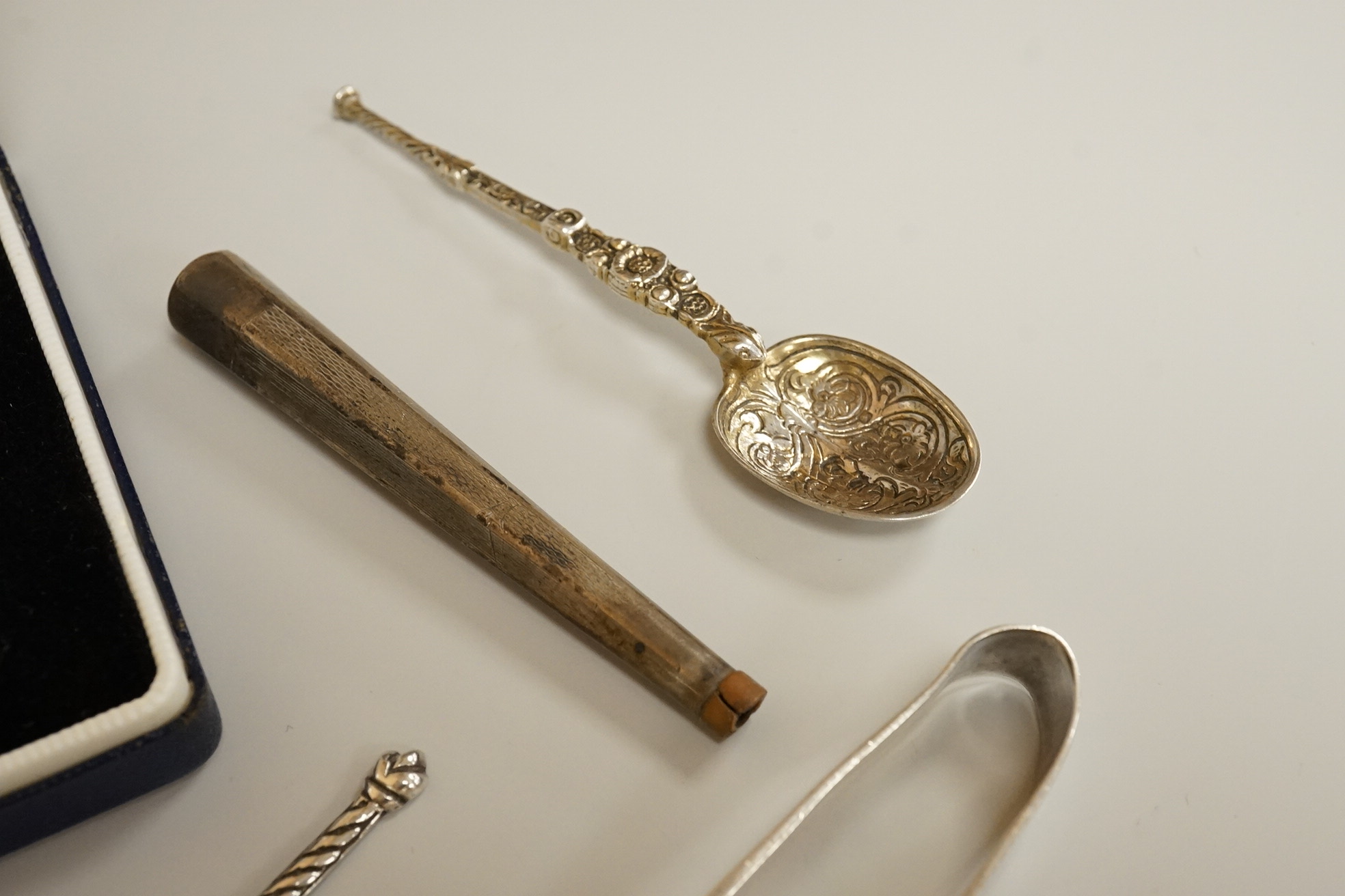 Assorted small silver including a mounted ribbed glass match strike, height 40mm, a small Scottish sterling spoon by Hamish Dawson Bowman, 76mm, a pair of George IV silver sugar tongs, commemorative spoons, an early 20th